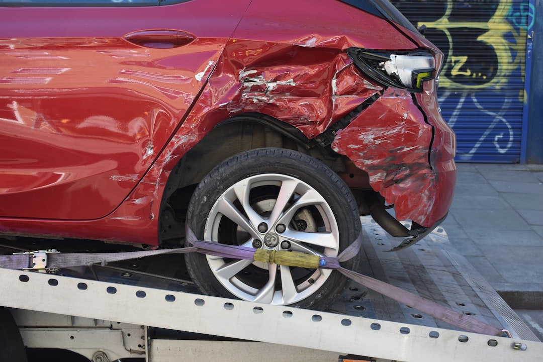 photo-1673187139211-1e7ec3dd60ec Image of a red car being towed/recovered which was involved in a road traffic collision.